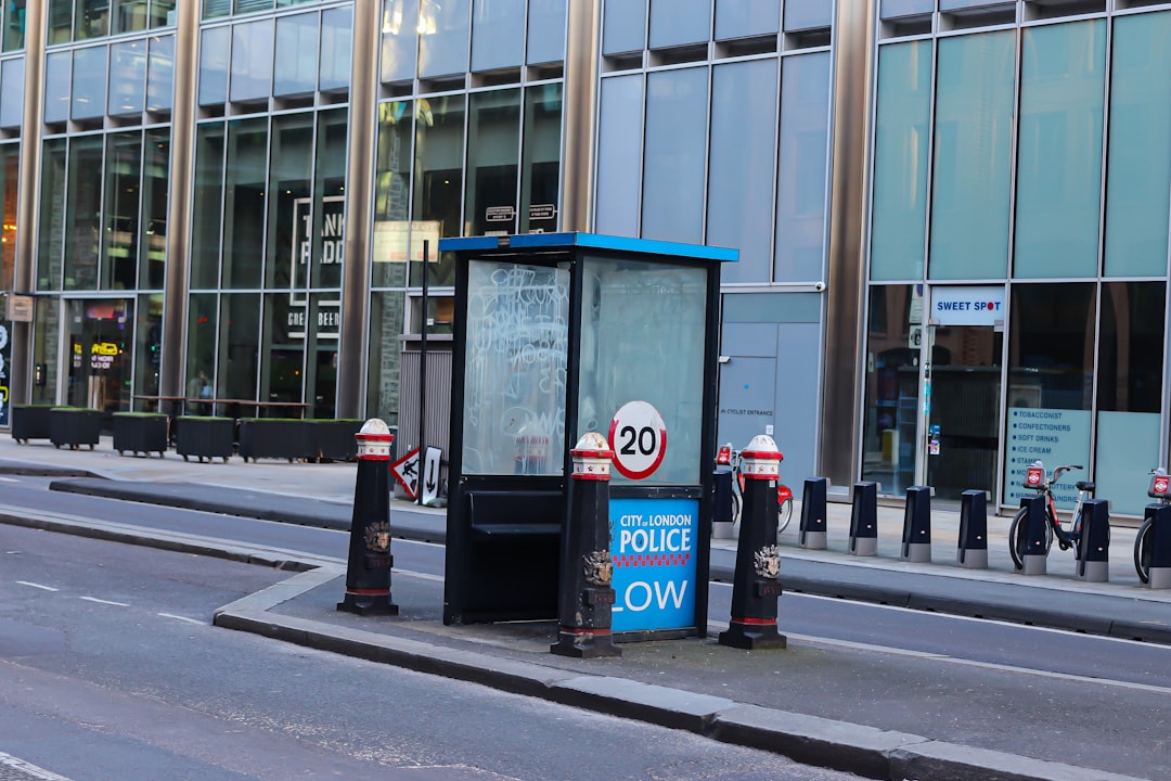 Bus stop shelter on a city street with modern buildings.