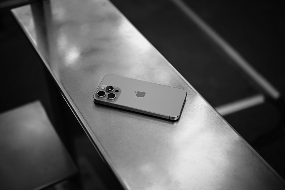 A smartphone rests on a metallic surface.