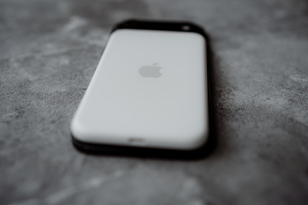 Back of an old white iPhone on a textured surface