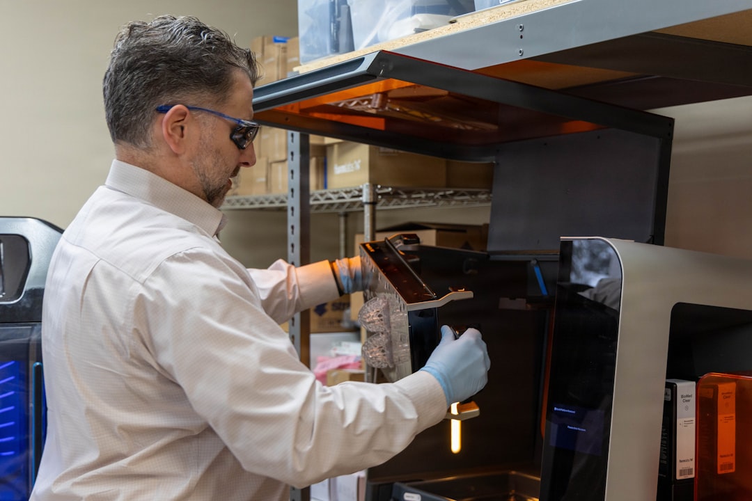 Man in gloves operating a 3D printer