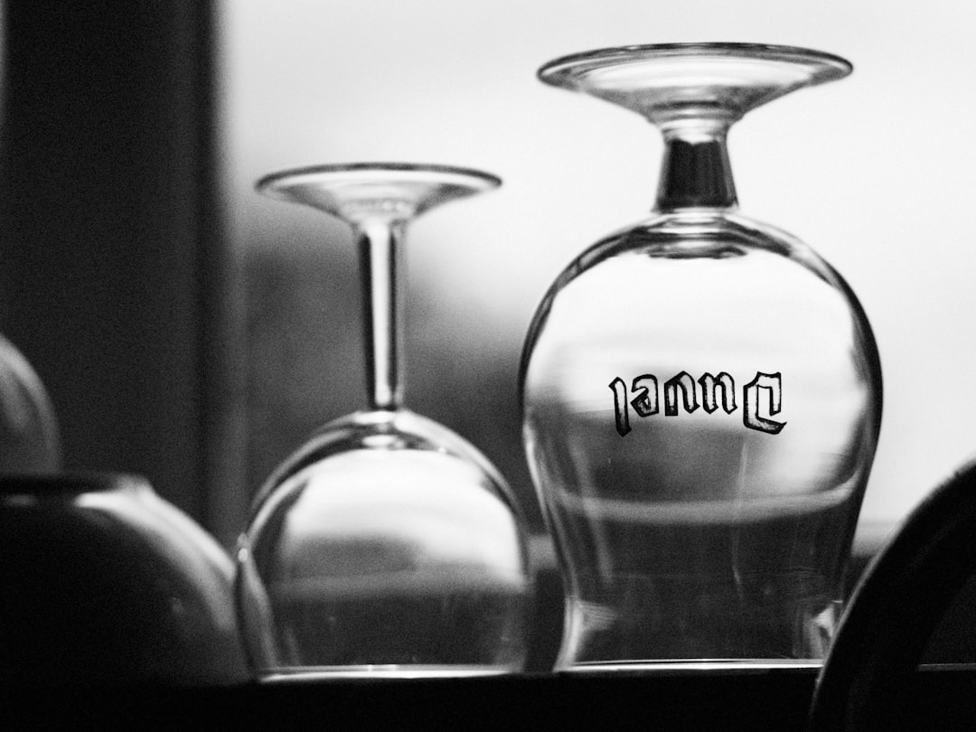 grayscale photo of clear glass bottle